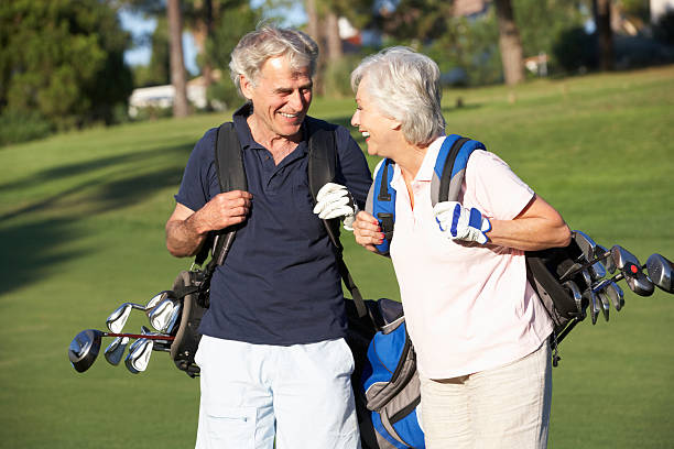 Man en vrouw lopen met golfclubs op grasveld