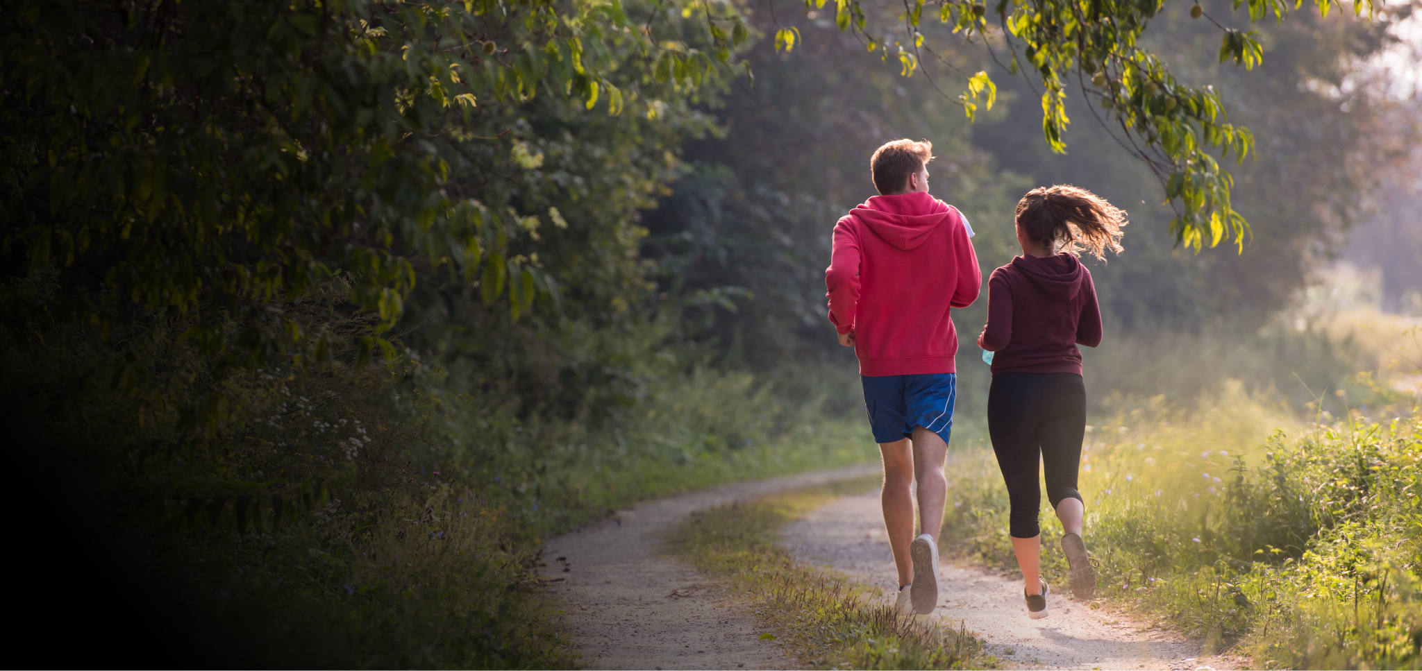 Twee mensen lopen hard op een bospad