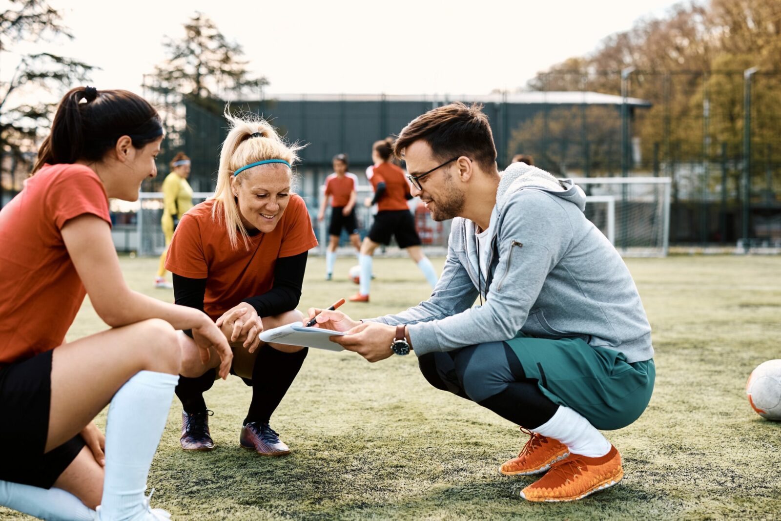 Mensen zitten gehurkt op een voetbalveld